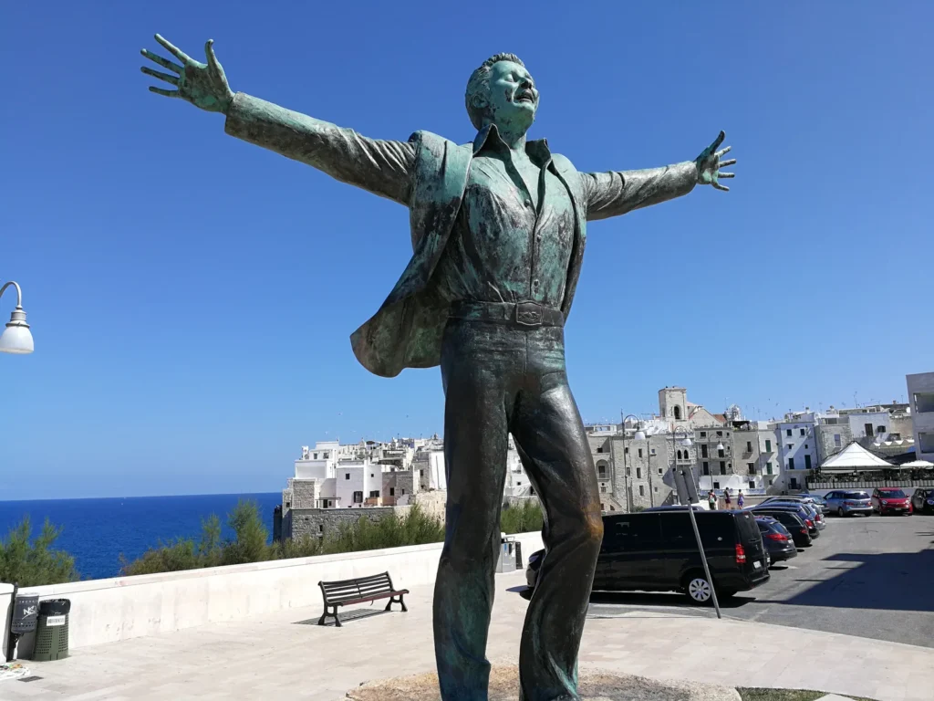 Estatua de Domenico Modugno junto al mar en Polignano a Mare