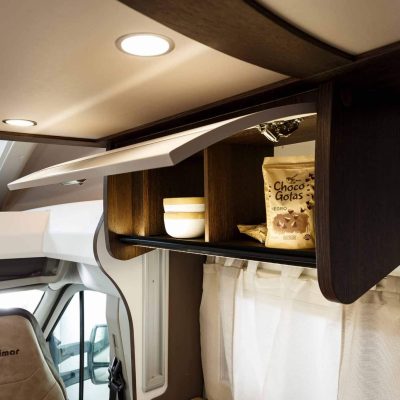 El interior de un rv con una mesa de café y estantes.
