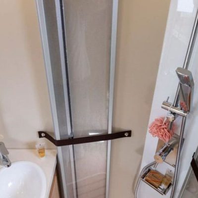 Un pequeño cuarto de baño con ducha y lavabo.