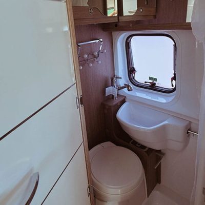 Un pequeño cuarto de baño con inodoro y lavabo.